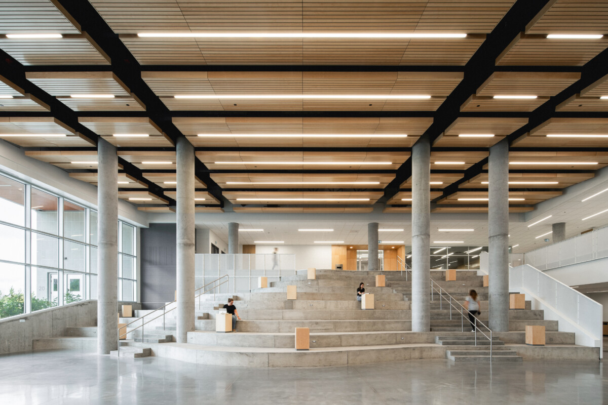 Irma LeVasseur Anjou Tignum suspended plank ceiling with integrated linear LED lighting and concrete columns.